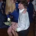 A brother serenades his date with the Sweetheart of Sigma Chi and a white rose.